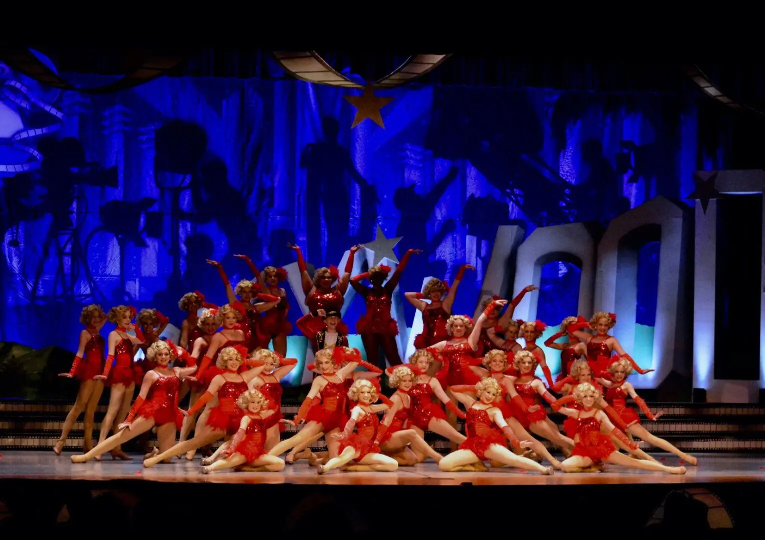 A group of people in red outfits on stage.