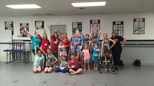 A group of people posing for the camera with skateboards.