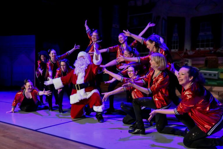A group of people on stage with santa clause.